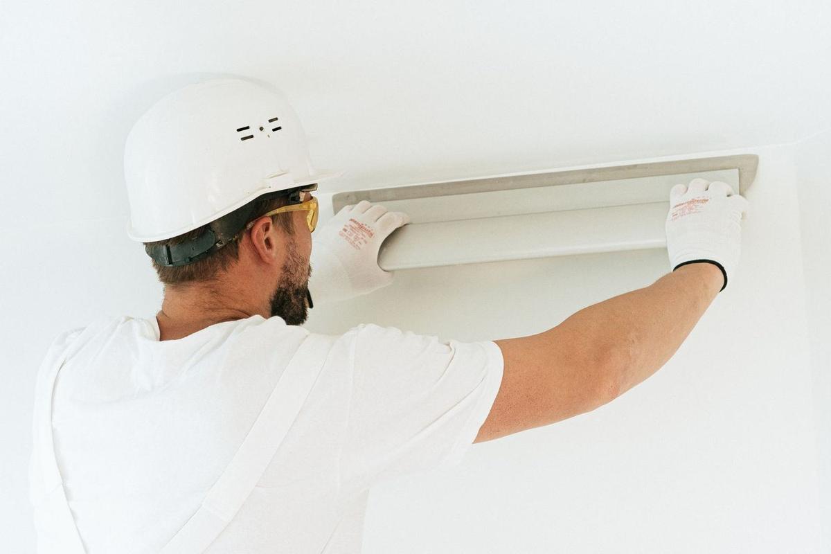 Electrician fitting a light at ceiling height